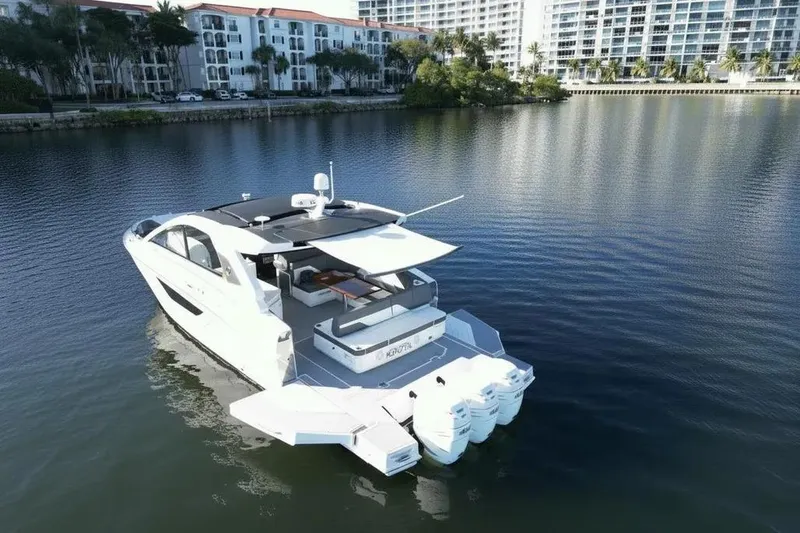 Slide: The Image of 2021 Cruisers Yachts 42 GLS OB on calm water near luxury waterfront buildings. - 7