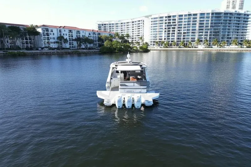 Slide: The Image of 2021 Cruisers Yachts 42 GLS OB on calm water near modern buildings. - 8