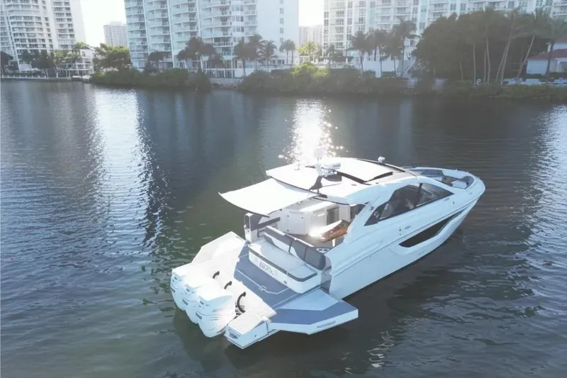 Slide: The Image of 2021 Cruisers Yachts 42 GLS OB on calm water near cityscape. - 9