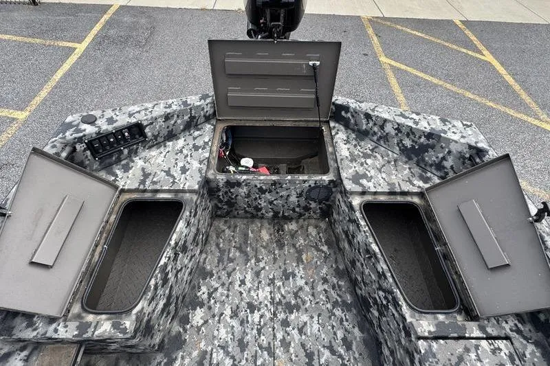 Slide: The Image of 2024 Havoc 1756 MRST boat interior with open storage compartments and camo design. - 13