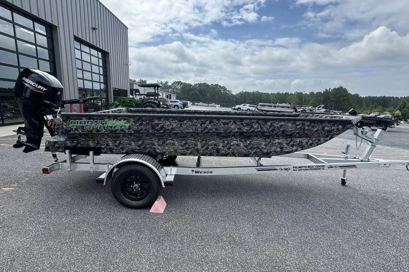 Slide: The Image of 2024 Havoc 1756 MRST boat on trailer, camo design, parked outdoors. - 6
