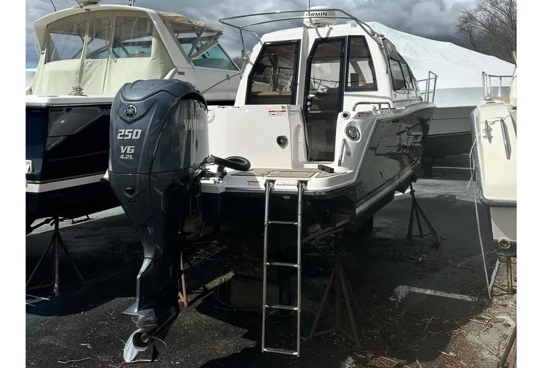 Slide: The Image of 2022 Cutwater C-24 Coupe interior with cushioned seating and wood-patterned flooring. - 19