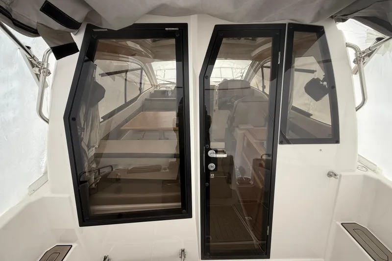 Slide: The Image of 2022 Cutwater C-24 Coupe interior view with glass doors and seating area. - 27