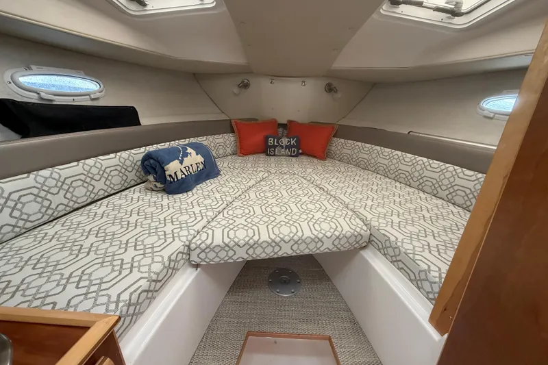 Slide: The Image of 2022 Cutwater C-24 Coupe cabin interior with patterned bedding and decorative pillows. - 47