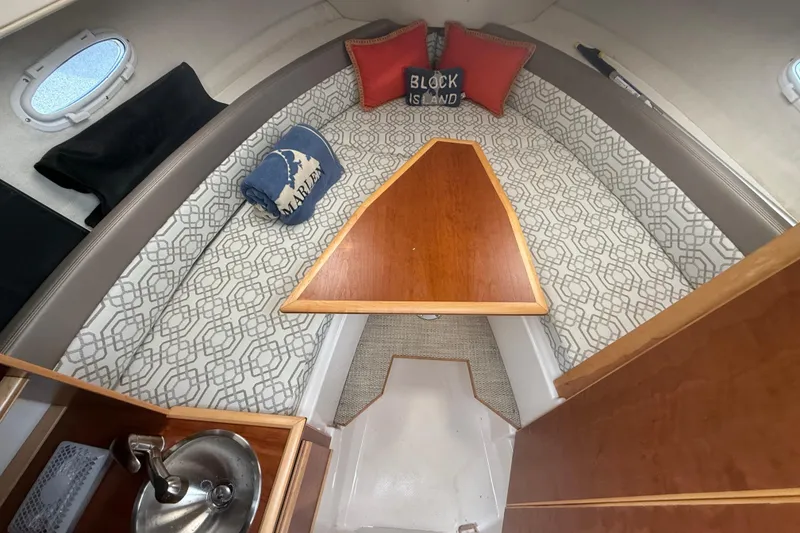 Slide: The Image of 2022 Cutwater C-24 Coupe cabin interior with patterned seating and wooden table. - 50