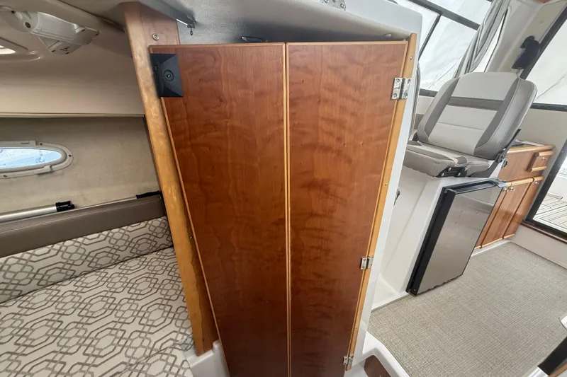 Slide: The Image of Interior of 2022 Cutwater C-24 Coupe, featuring wood cabinetry and seating area. - 53