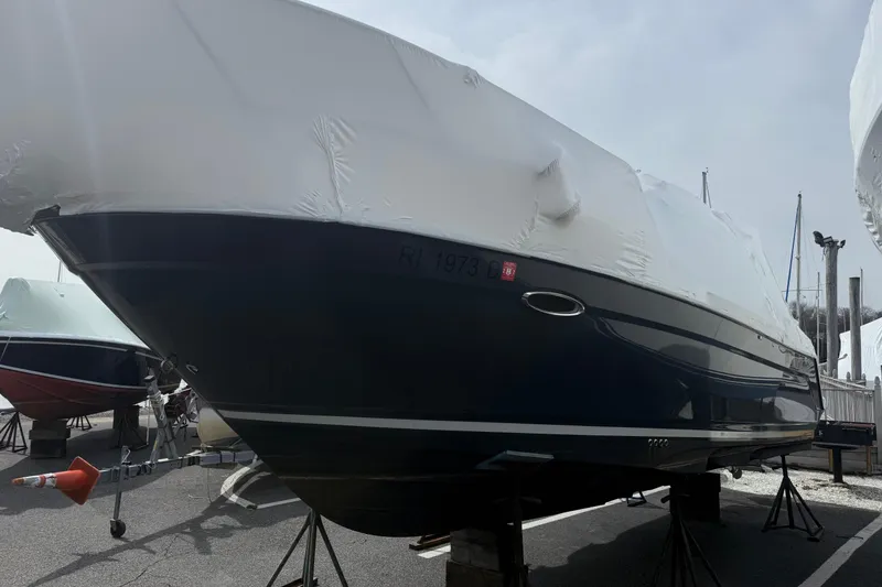 Slide: The Image of 2022 Cutwater C-24 Coupe boat covered and stored on stands in a marina. - 67
