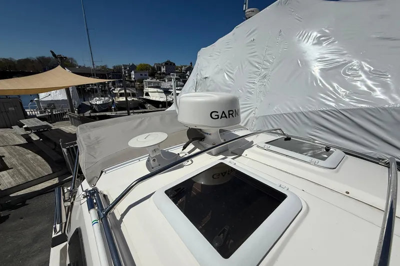 Slide: The Image of 2022 Cutwater C-24 Coupe boat with Garmin radar, docked at a marina under clear skies. - 69