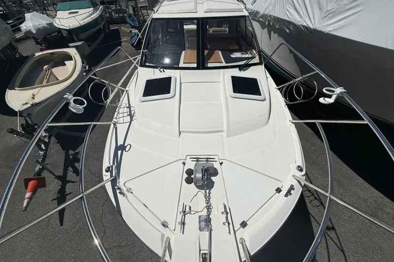 Slide: The Image of 2022 Cutwater C-24 Coupe boat docked, showcasing sleek design and spacious deck. - 72