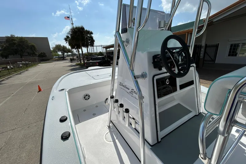 Slide: The Image of 2026 Shallow Stalker The Boss boat, sleek design, parked outdoors under a sunny sky. - 12