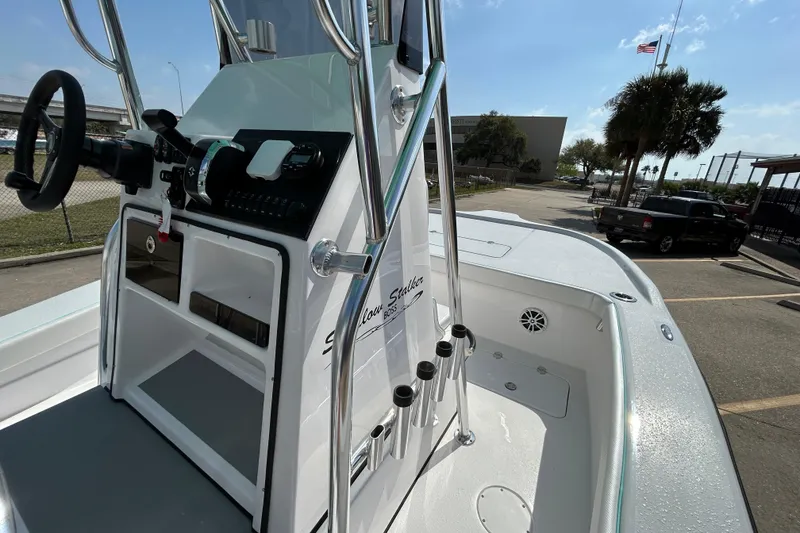 Slide: The Image of 2026 Shallow Stalker The Boss boat console with steering wheel and controls, parked outdoors. - 13