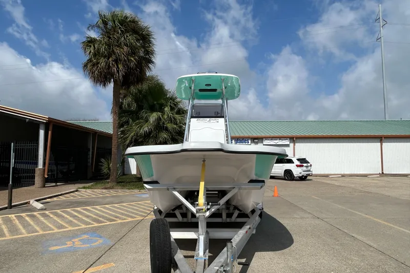 Slide: The Image of 2026 Shallow Stalker "The Boss" boat on trailer, parked under blue sky. - 2
