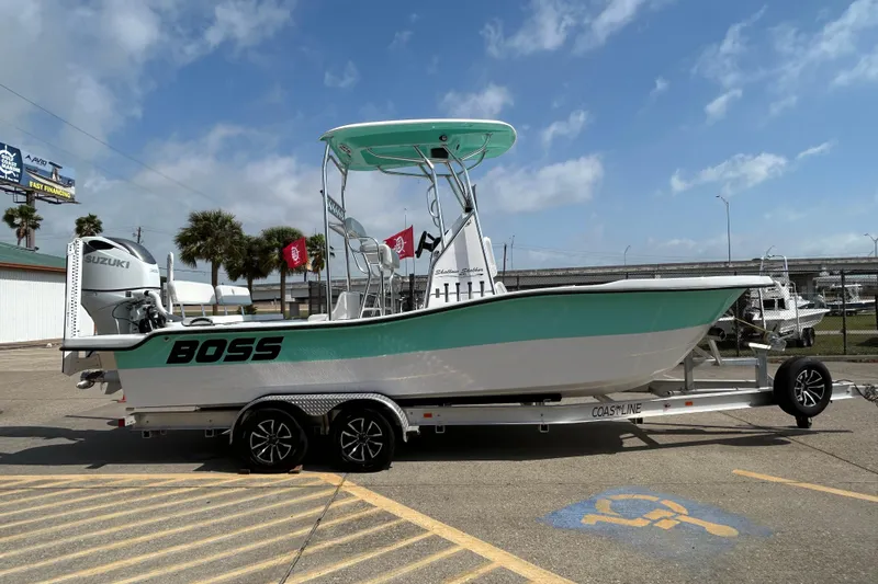 Slide: The Image of 2026 Shallow Stalker "The Boss" boat on trailer, featuring Suzuki engine, parked outdoors. - 4