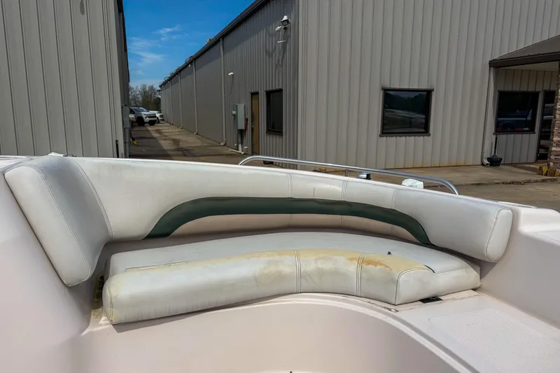 Slide: The Image of 2003 Hurricane FunDeck GS 188 OB boat interior with white seating, near industrial building. - 11