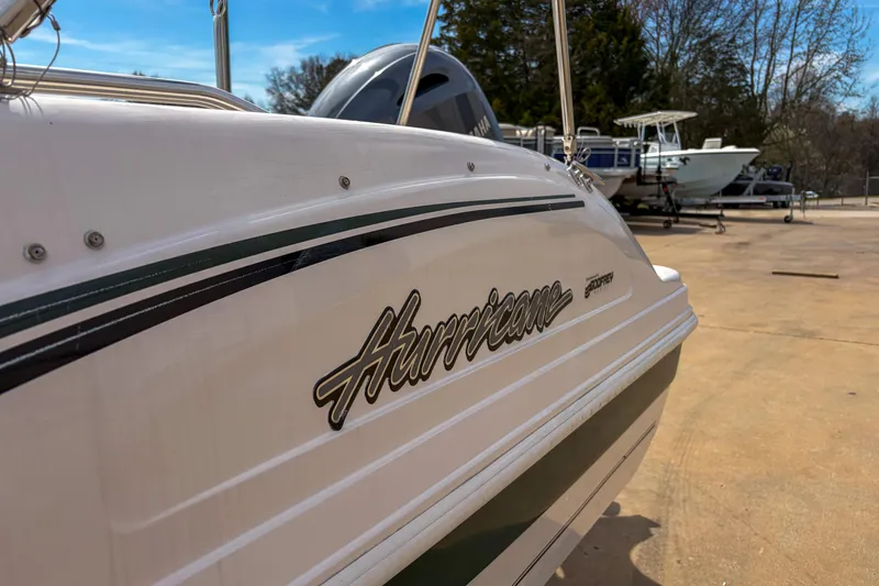 Slide: The Image of 2003 Hurricane FunDeck GS 188 OB boat, white with green accents, parked outdoors. - 3