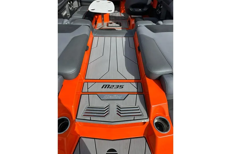 Slide: The Image of 2017 Malibu M235 boat interior with orange accents and gray seating. - 11