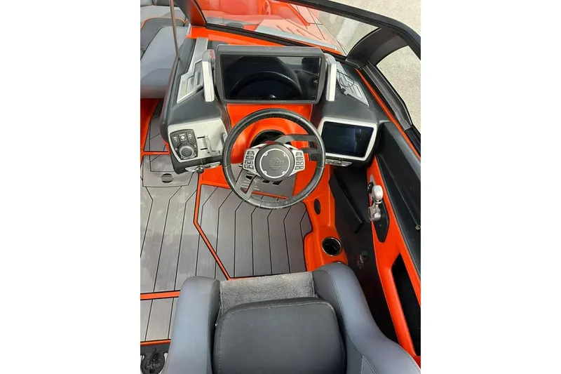 Slide: The Image of 2017 Malibu M235 boat cockpit with modern steering and digital displays. - 7