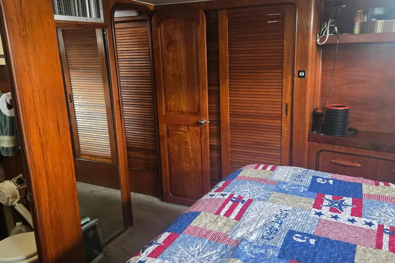 Slide: The Image of Cozy bedroom in a 1979 Gulfstar 44 yacht with nautical-themed quilt. - 13