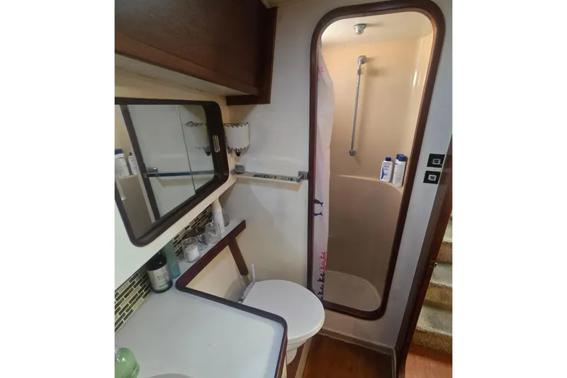 Slide: The Image of 1979 Gulfstar 44 yacht bathroom with shower, mirror, and storage shelves. - 19