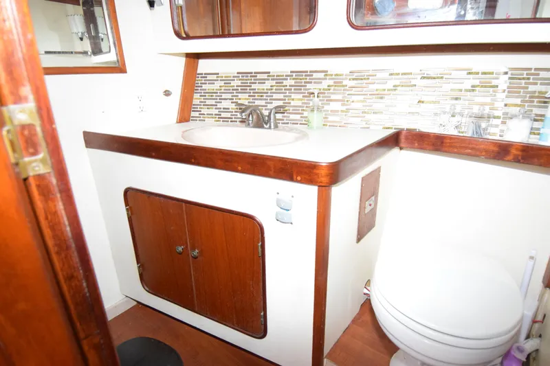 Slide: The Image of 1979 Gulfstar 44 yacht bathroom with wooden cabinetry and modern backsplash. - 21