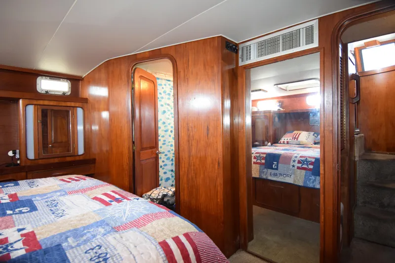 Slide: The Image of Cozy 1979 Gulfstar 44 yacht cabin with wooden interior and nautical-themed bedding. - 27