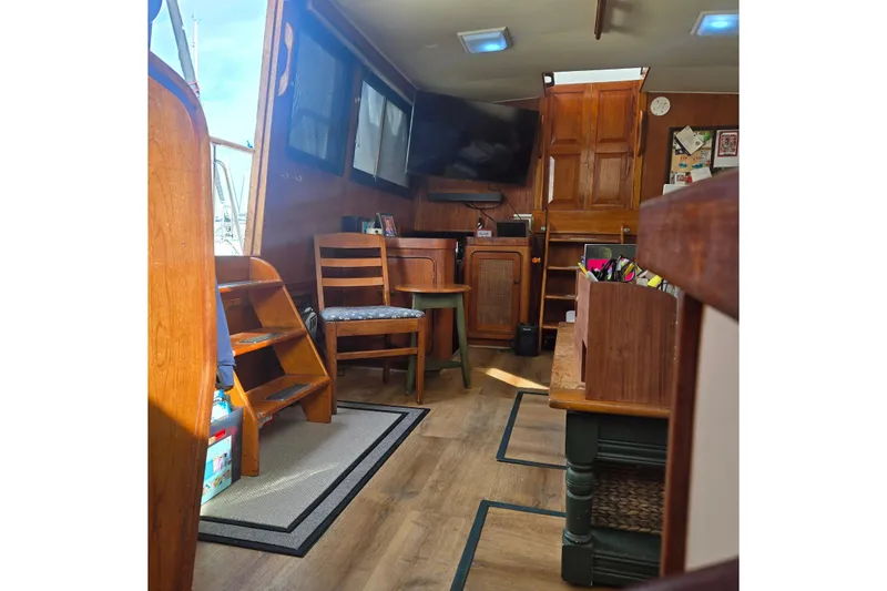 Slide: The Image of Cockpit of 1979 Gulfstar 44 yacht with striped seating and wooden table in marina. - 3