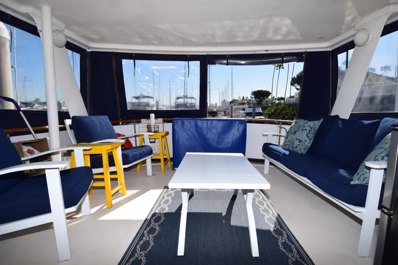 Slide: The Image of 1979 Gulfstar 44 yacht interior with blue seating, white table, and marina view. - 35