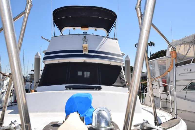 Slide: The Image of 1979 Gulfstar 44 yacht docked at marina, featuring a covered upper deck and sleek design. - 41