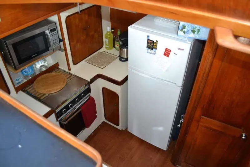 Slide: The Image of Cozy interior of a 1979 Gulfstar 44 boat with sofa, storage, and wooden decor. - 6