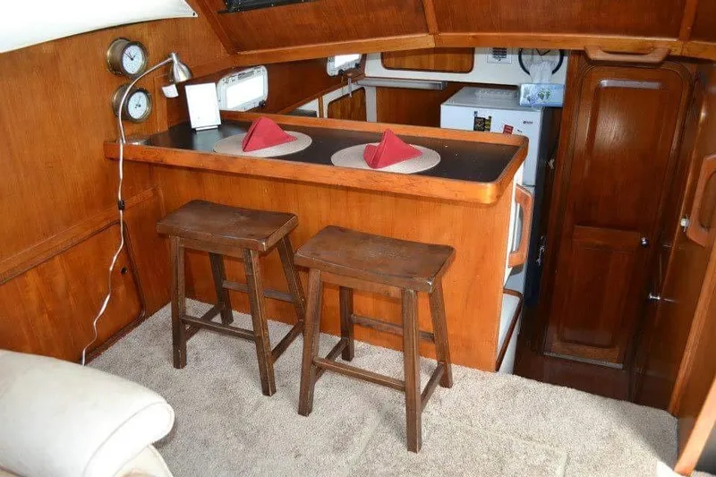 Slide: The Image of 1979 Gulfstar 44 interior with wooden stairs, storage, and nautical decor. - 7