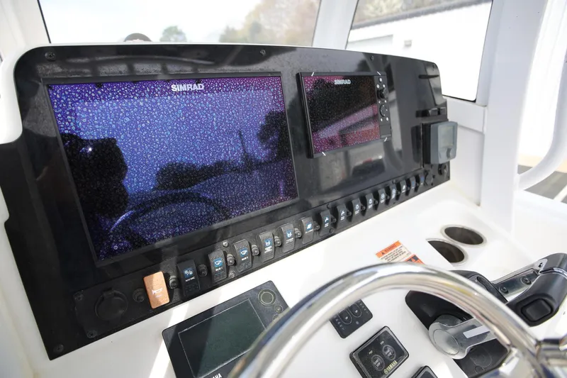 Slide: The Image of 2018 Sea Hunt Gamefish 25 dashboard with Simrad displays and controls. - 13