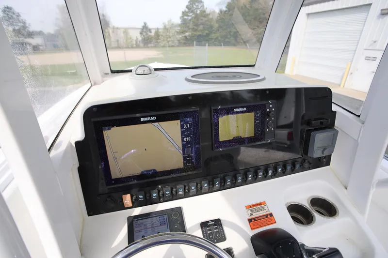 Slide: The Image of 2018 Sea Hunt Gamefish 25 dashboard with dual Simrad displays and control panel. - 15