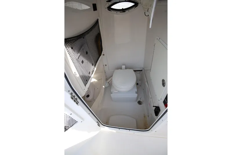 Slide: The Image of 2018 Sea Hunt Gamefish 25 boat interior with compact marine toilet and storage. - 21