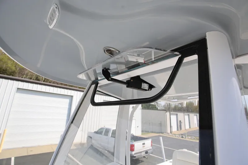 Slide: The Image of 2018 Sea Hunt Gamefish 25 boat windshield and T-top detail in a marina setting. - 23