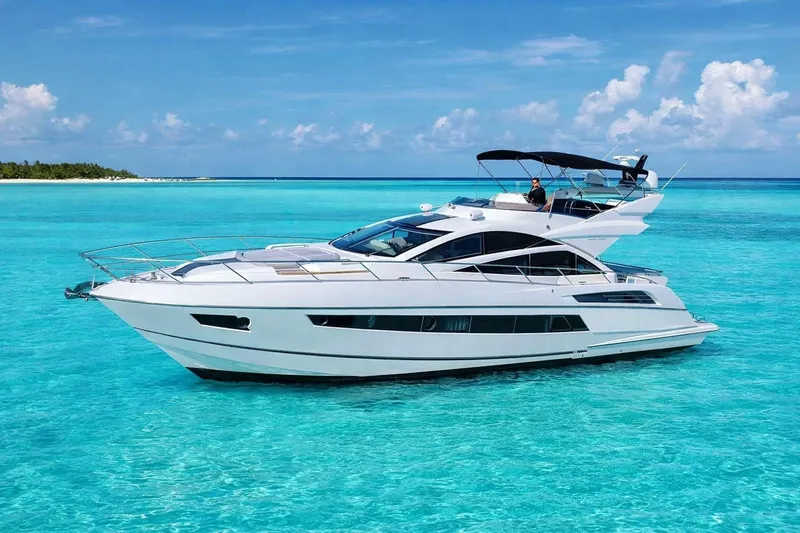 The Image of 2014 Sunseeker 68 Sport Yacht cruising in clear turquoise waters. - 1