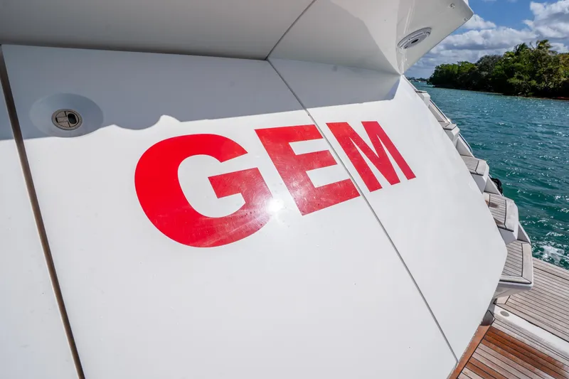 Slide: The Image of Sunseeker 68 Sport Yacht 2014 with "GEM" lettering, docked by scenic waters. - 14