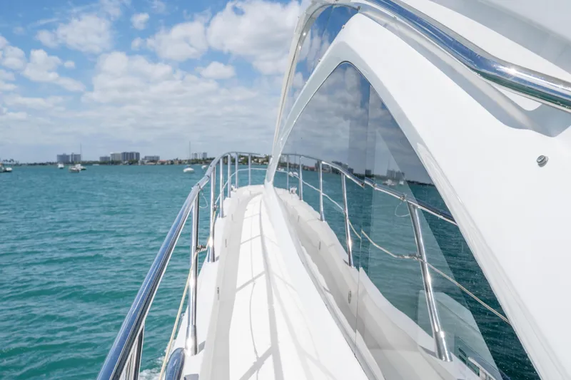 Slide: The Image of Sunseeker 68 Sport Yacht 2014 cruising on clear blue waters under a partly cloudy sky. - 55