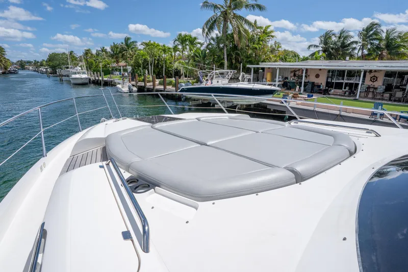 Slide: The Image of 2014 Sunseeker 68 Sport Yacht docked by a scenic waterfront with palm trees. - 56