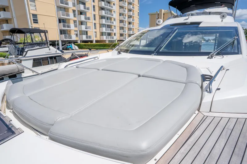 Slide: The Image of 2014 Sunseeker 68 Sport Yacht with sunpad, docked near waterfront buildings. - 57