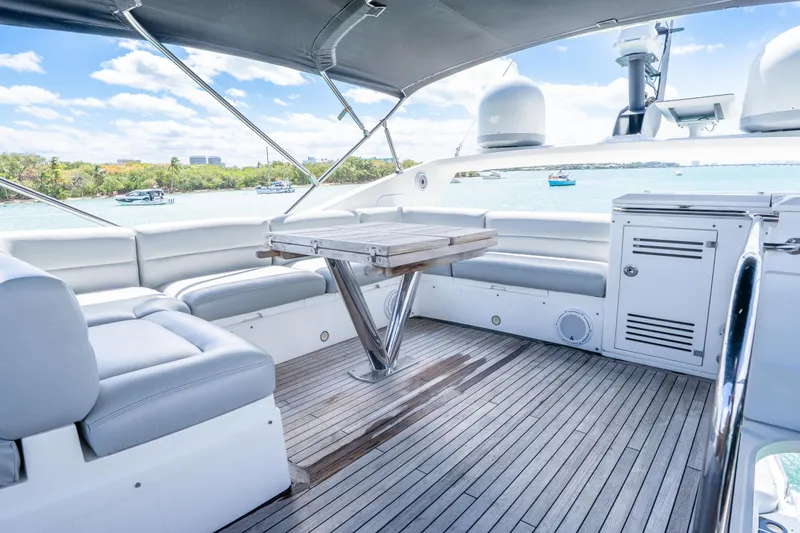Slide: The Image of Luxurious 2014 Sunseeker 68 Sport Yacht deck with seating, table, and scenic water view. - 63