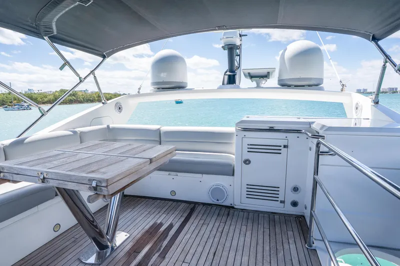 Slide: The Image of Sunseeker 68 Sport Yacht 2014 deck with seating and table, overlooking serene waters. - 64