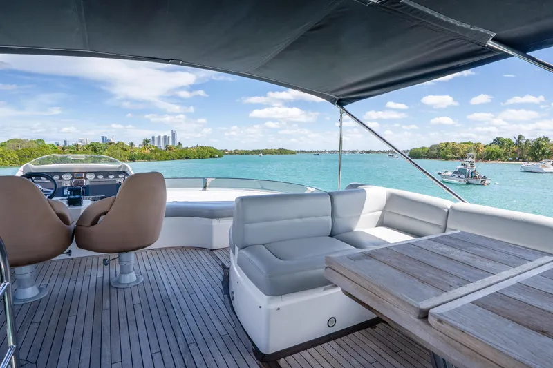 Slide: The Image of Luxurious 2014 Sunseeker 68 Sport Yacht deck with seating, overlooking scenic waterfront. - 65