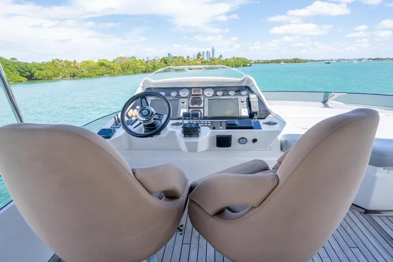 Slide: The Image of Helm of 2014 Sunseeker 68 Sport Yacht with dual seats, overlooking serene waters. - 68