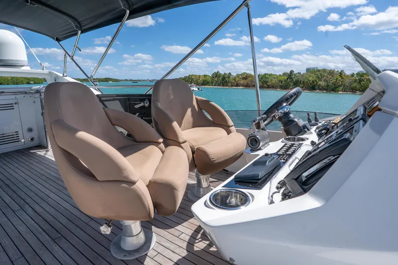 Slide: The Image of Flybridge of 2014 Sunseeker 68 Sport Yacht with dual helm seats and scenic water view. - 69
