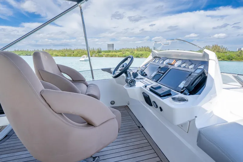 Slide: The Image of Luxurious helm of 2014 Sunseeker 68 Sport Yacht with modern controls and plush seating. - 70