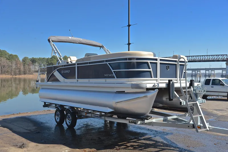 Slide: The Image of 2025 Godfrey Sweetwater 2086 C pontoon boat on trailer by a lake. - 16