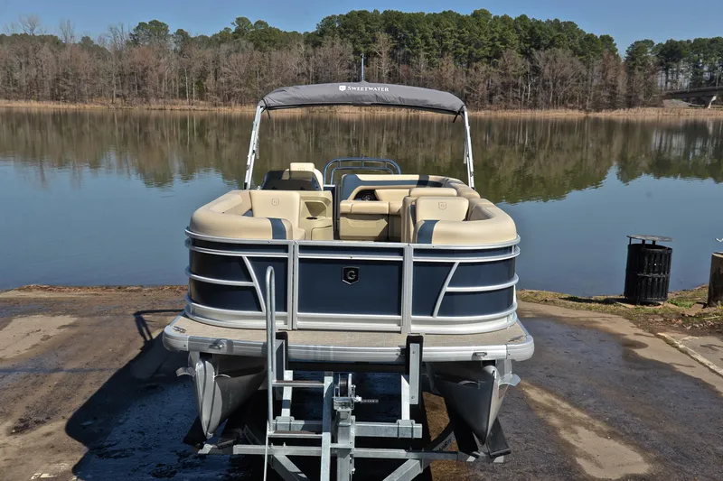 Slide: The Image of 2025 Godfrey Sweetwater 2086 C pontoon boat on trailer by a serene lake. - 17