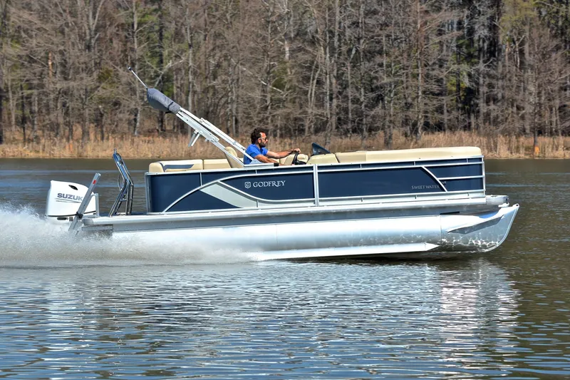 Slide: The Image of 2025 Godfrey Sweetwater 2086 C pontoon boat cruising on a lake. - 3