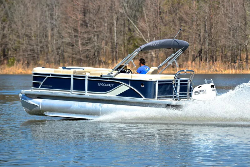 Slide: The Image of 2025 Godfrey Sweetwater 2086 C pontoon boat cruising on a lake. - 4