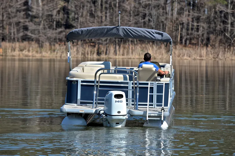 Slide: The Image of 2025 Godfrey Sweetwater 2086 C pontoon boat cruising on a calm lake. - 7